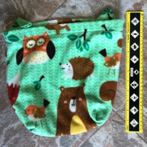 A green bag with animals on it and a ruler