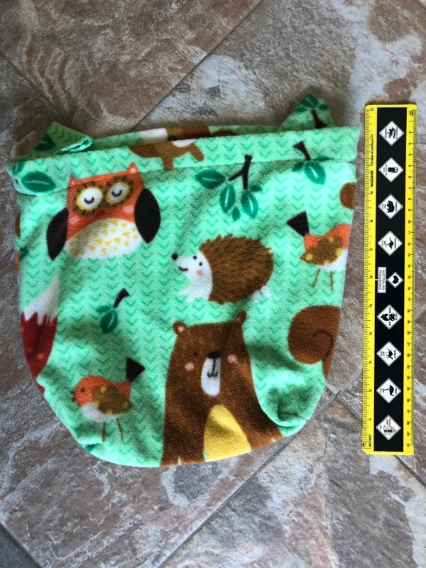 A green bag with animals on it and a ruler